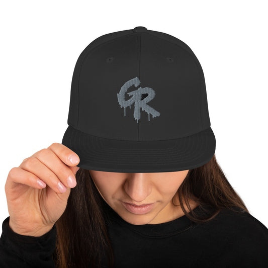 Model wearing the black Concrete Fairways disc golf snapback, front view with the light gray drip GR embroidery